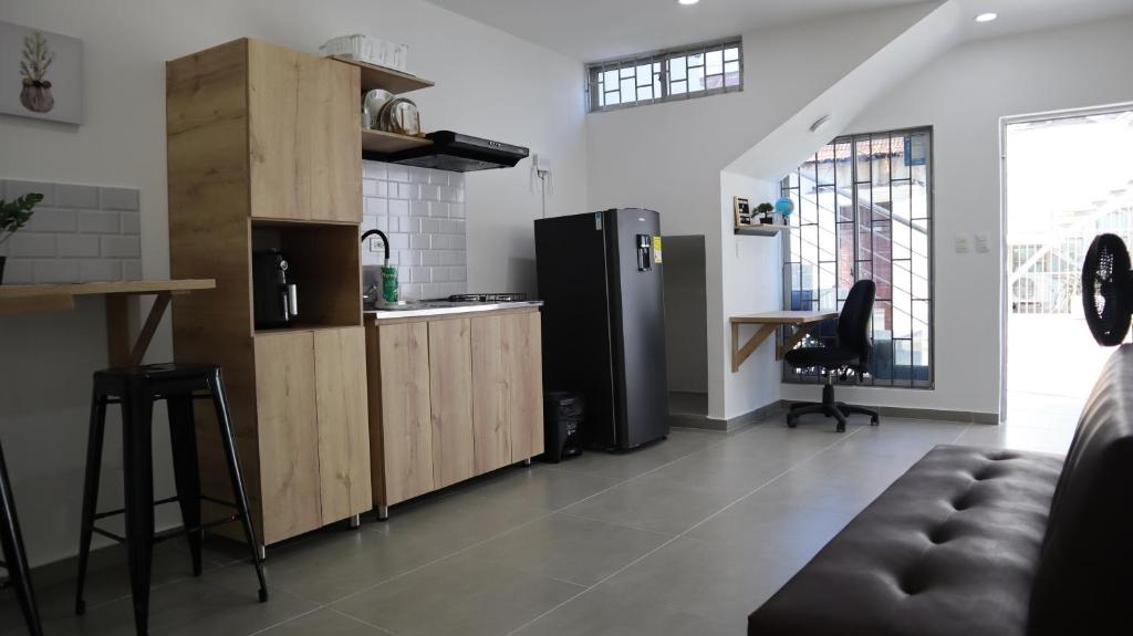 里奥阿查D'Rio Aparta estudios的厨房配有黑色冰箱和桌子
