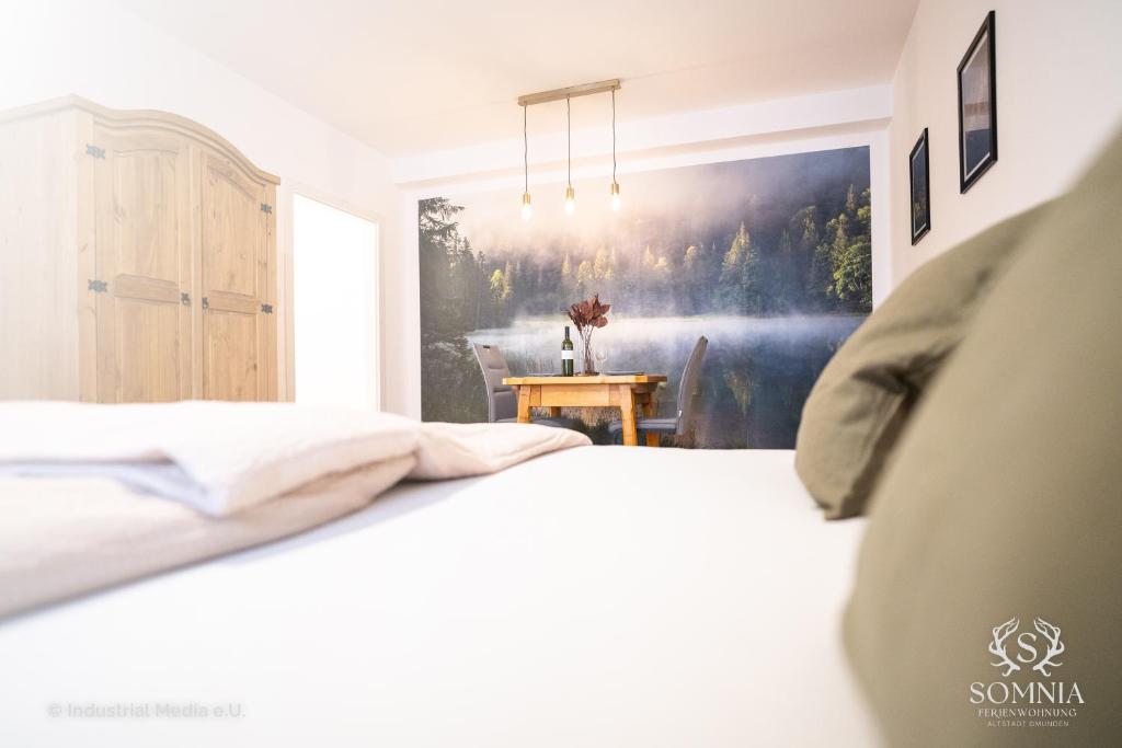 格蒙登Ferienwohnung Somnia - Altstadt Gmunden的卧室配有一张床,墙上挂有绘画作品