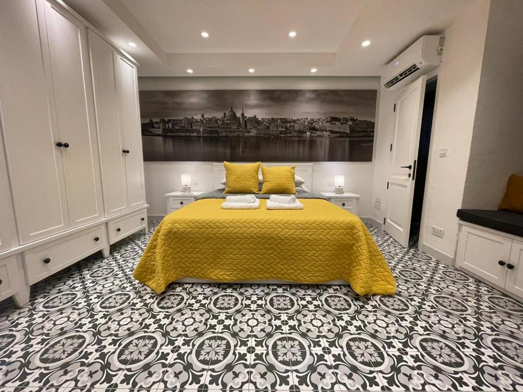 瓦莱塔Valletta Home -Dar il-Kavallier Jacques de Quiqueran的一间卧室配有一张黄色床罩的床
