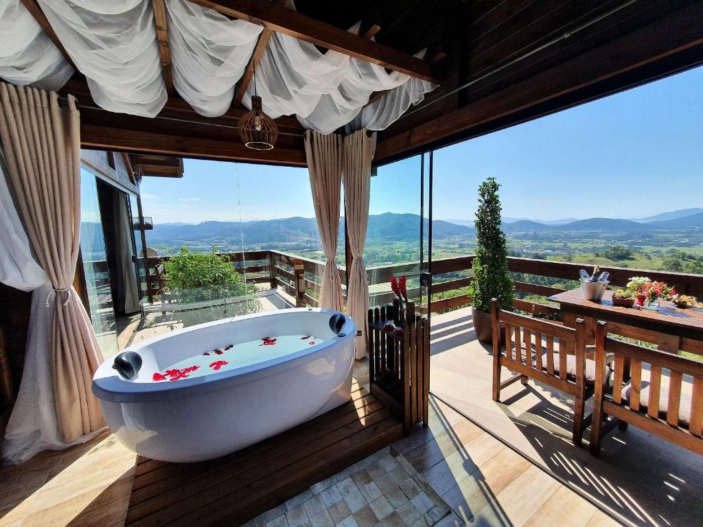 圣阿马鲁-达因佩拉特里斯Chalé da Montanha com Ofurô的观景甲板上设有带浴缸的浴室