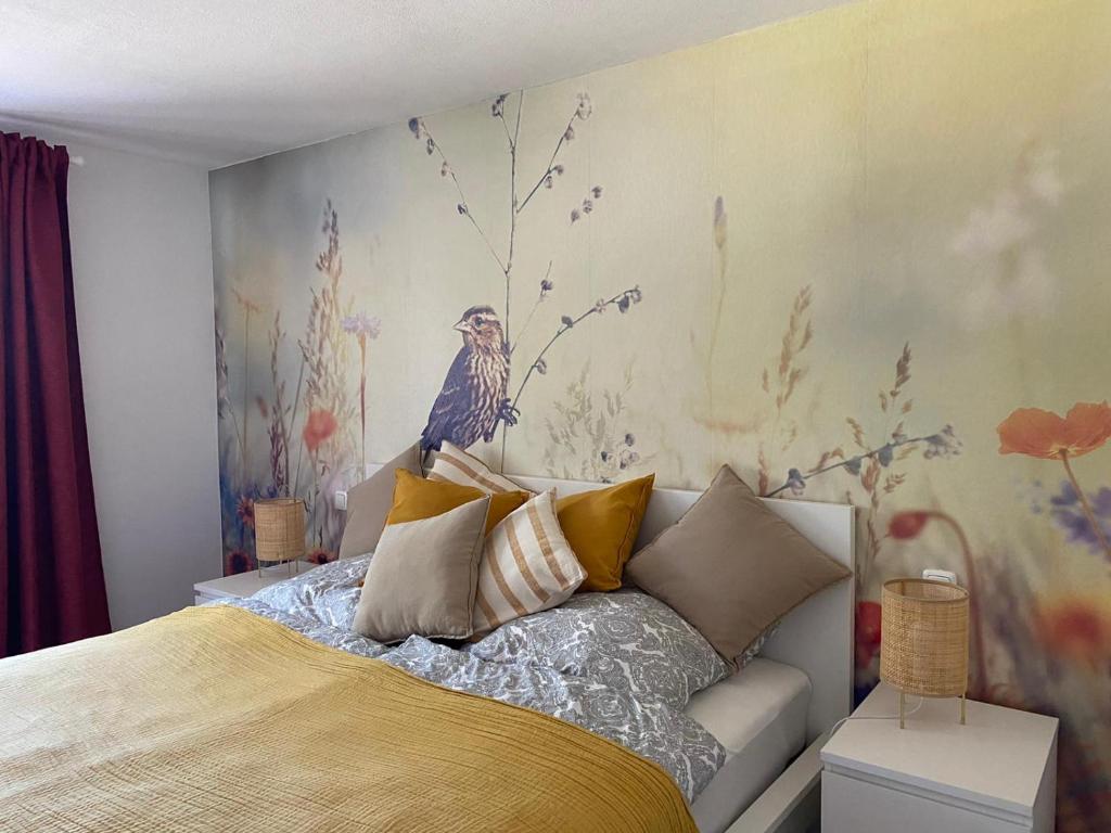 LindenVogelnest的卧室配有一张床上,墙上挂着鸟