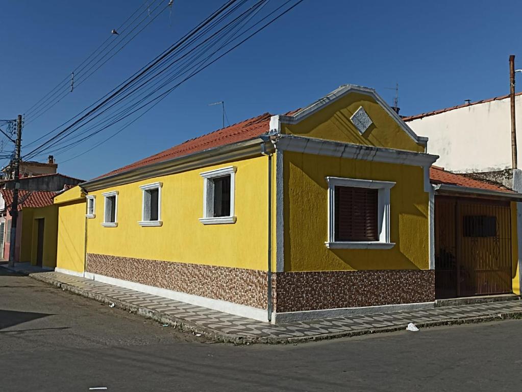 阿帕雷西达Casa a 5 minutos a pé da Basílica e da feira em Aparecida的街道边的黄色建筑