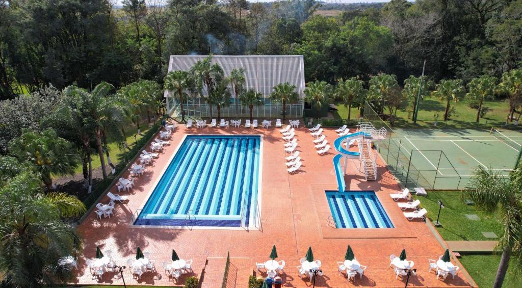 伊瓜苏Hotel Nacional Inn Foz do Iguaçu的享有带椅子的游泳池和网球场的空中景致