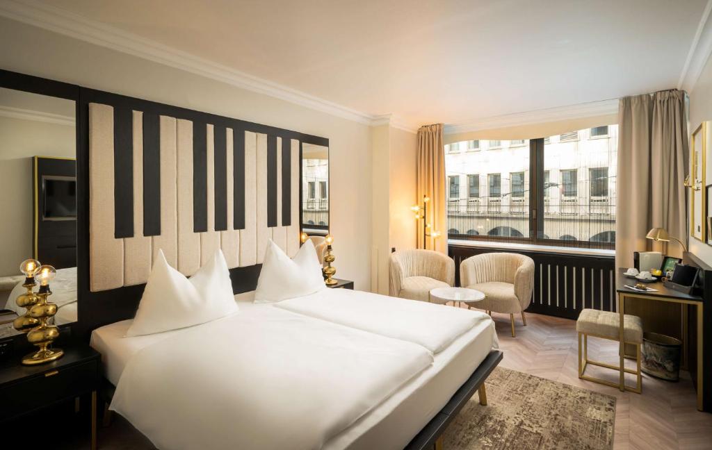 维也纳elaya hotel vienna city center的卧室设有一张白色大床和大窗户