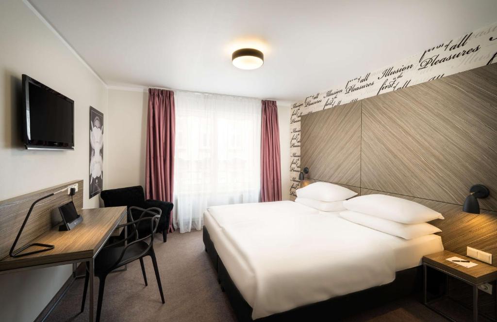 维也纳elaya hotel vienna city west的配有一张床和一张书桌的酒店客房