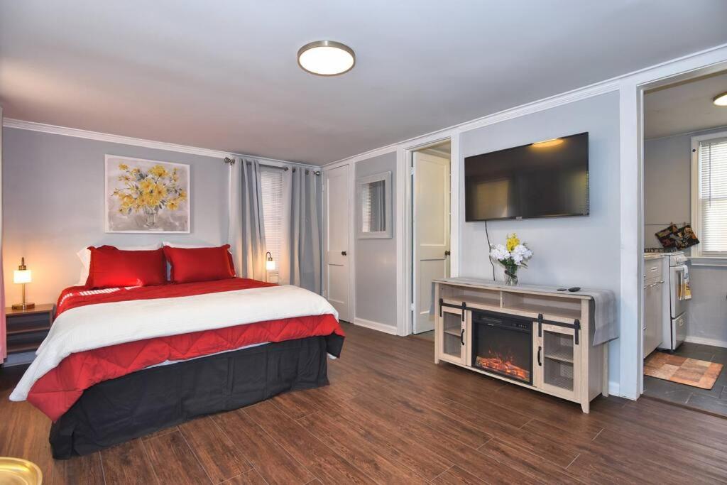 塔尔萨BLUE FLAMINGO'S ADORABLE GUEST HOUSE -TU-Cherry St-Expo-Downtown-11t的一间卧室配有一张带红色枕头的床和电视。