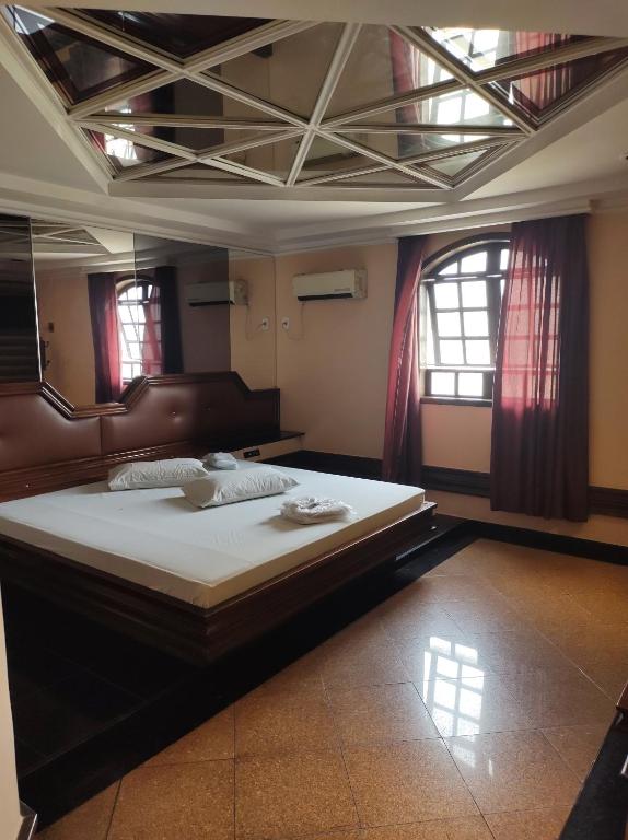 里约热内卢Champion motel的一间带一张大床的卧室,位于带窗户的房间内