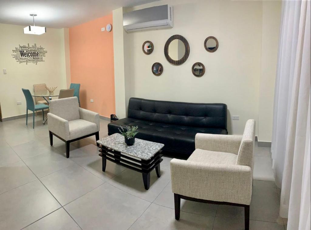瓜亚基尔Garzota Suites Gardens的客厅配有沙发、椅子和桌子