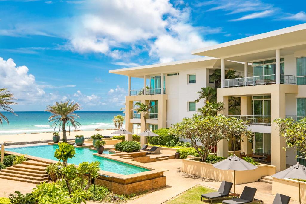 卡伦海滩Happy Apartment on Karon Beach的享有带游泳池和海滩的度假村外部景色
