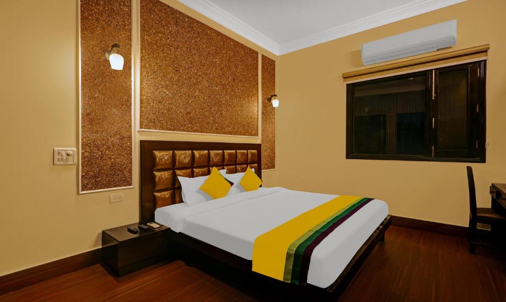 新德里Itsy By Treebo - Connaught Mews的一间卧室配有一张黄色和黄色毯子的床