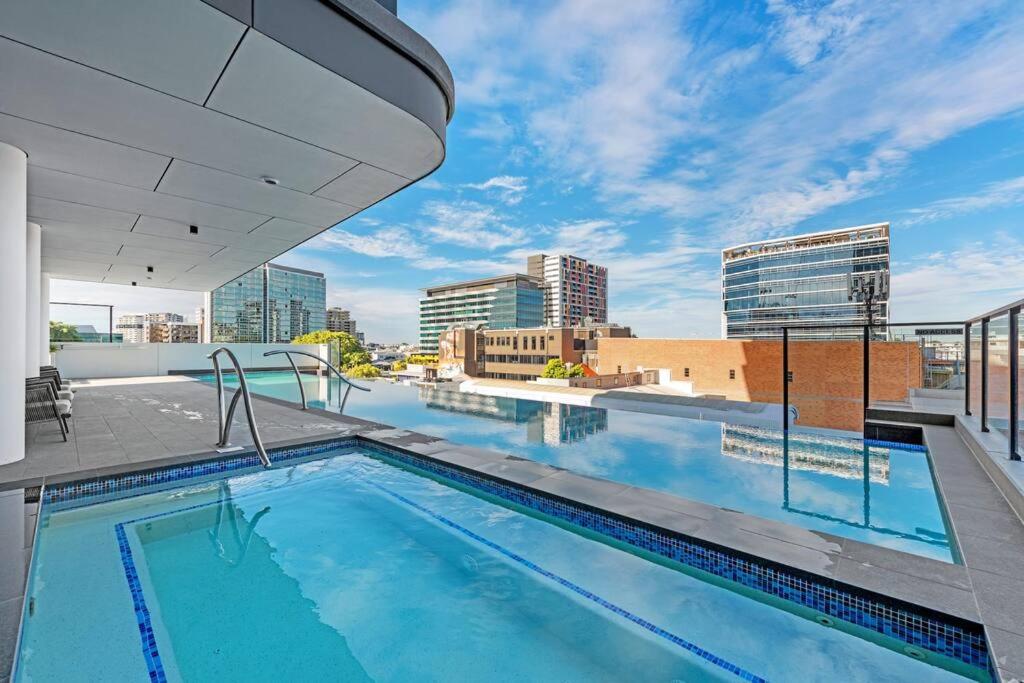 布里斯班Great located unit/Private Balcony, Pool,Gym,Parking的一座城市建筑屋顶上的游泳池