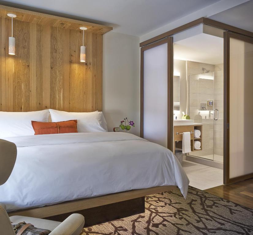 伯灵顿佛蒙特伯灵顿酒店的一间带白色大床的卧室和一间浴室
