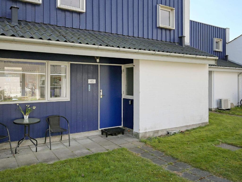 博托比Holiday home Væggerløse CCXIII的蓝色和白色的房子,配有桌子和椅子