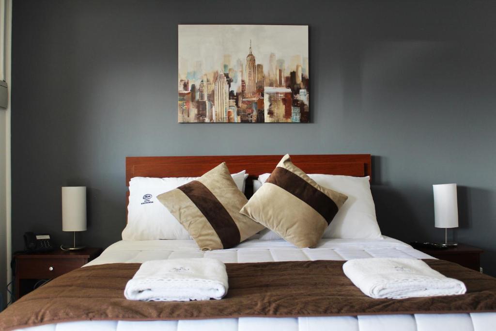 奥索尔诺Hotel Mackenna的一间卧室配有一张大床和两个枕头
