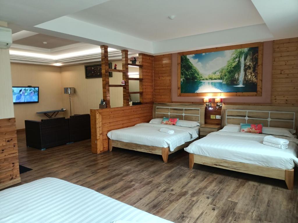 马六甲Hotel Balik Pulau的酒店客房设有两张床和一台平面电视。