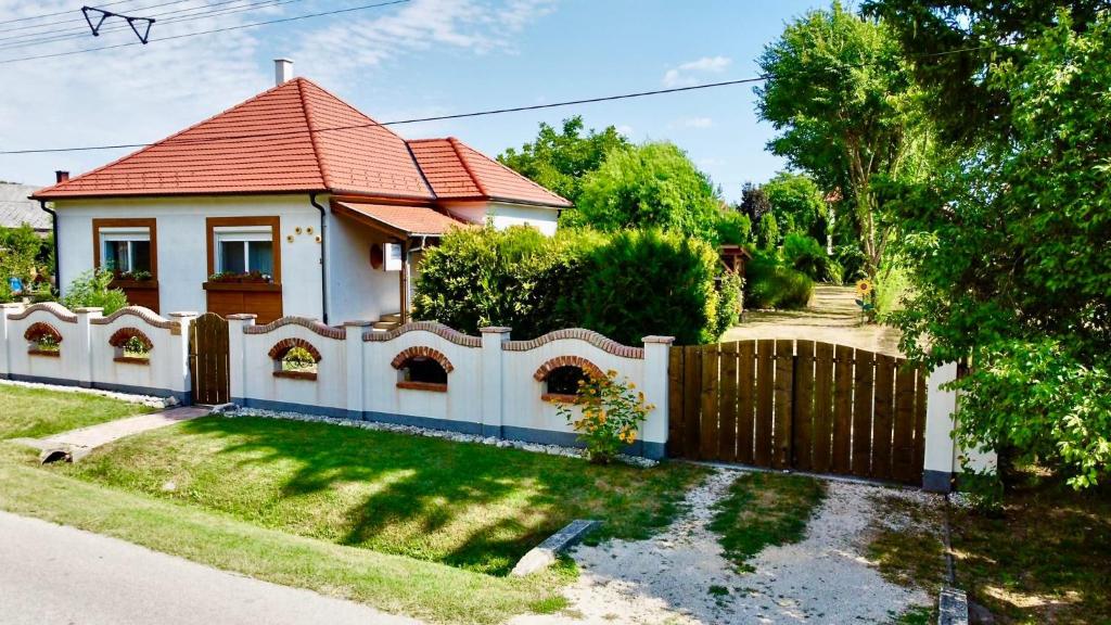 BakonyszentlászlóDöre Vendégház的白色的房子,有栅栏和院子