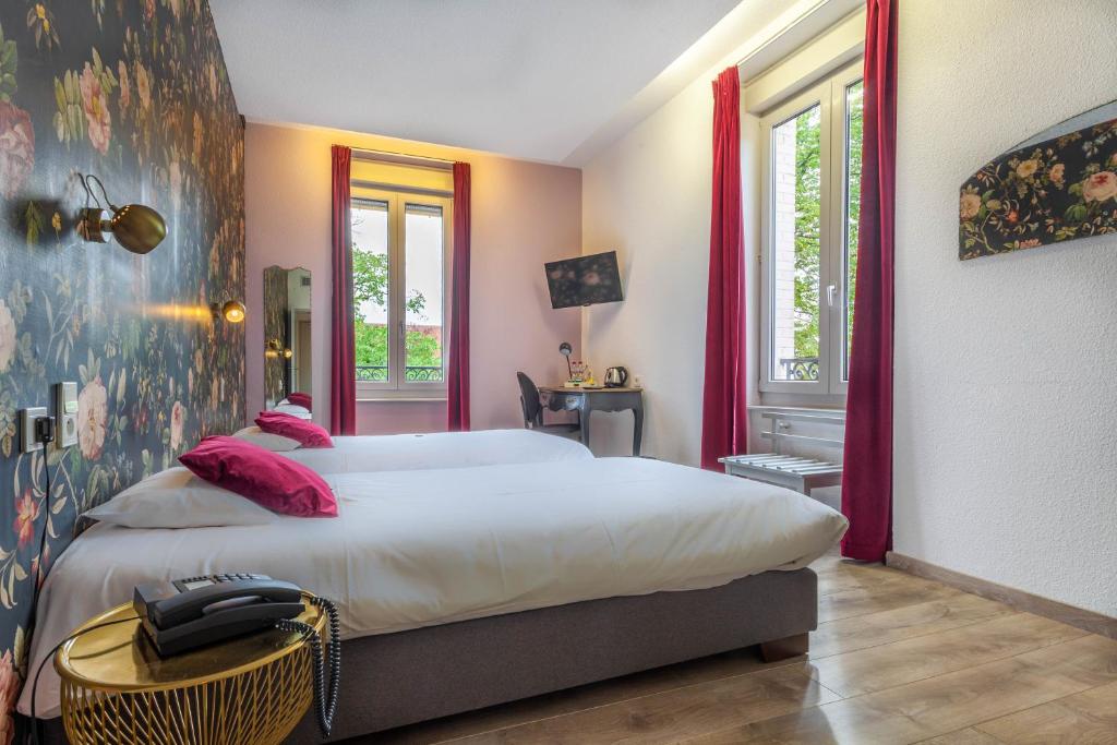 维泰勒Hôtel d'Angleterre (by Popinns)的卧室配有带粉红色枕头的大型白色床