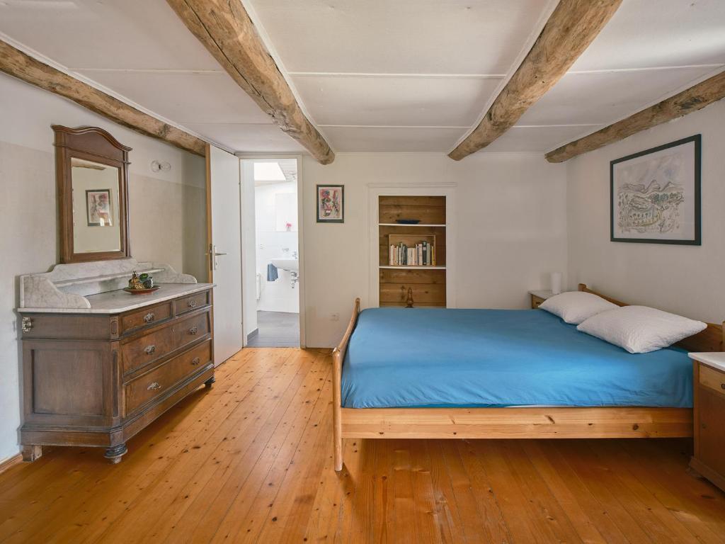 BorgnoneOsteria Grütli con alloggio的一间卧室配有蓝色的床和梳妆台