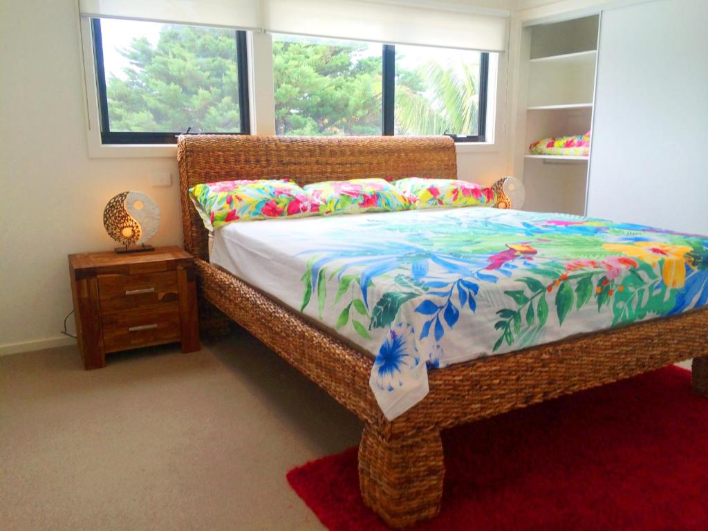 弗兰克斯顿获奖海滨度假酒店的一间卧室配有一张带五颜六色棉被的床