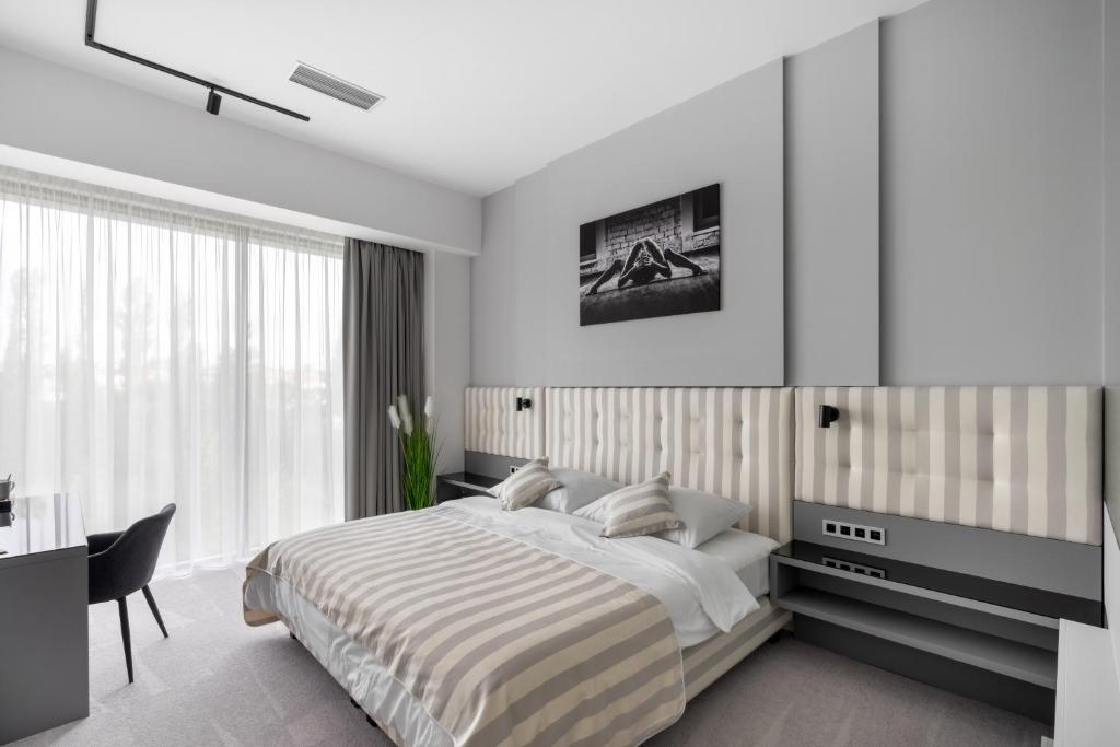 布拉格Port Karolina Luxury Residence的白色的卧室设有床、书桌和窗户