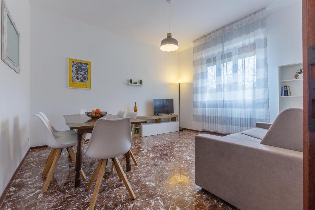 费拉拉Ferrara Charming apt 4 min walk from the bus stop!的客厅配有沙发和桌椅