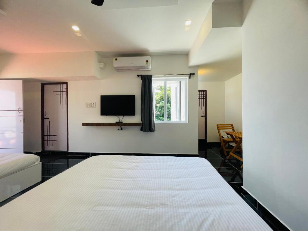 蓬蒂切里Villa Bordeaux的卧室配有一张床,墙上配有电视。