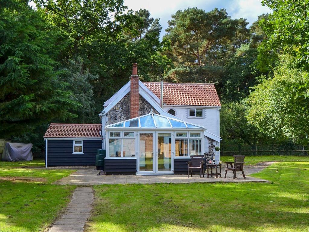 MundfordTree Tops Cottage的院子中带温室的小房子