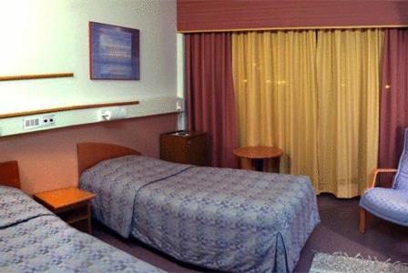 HaapavesiHotelli Haapakannel的酒店客房,配有两张床和椅子