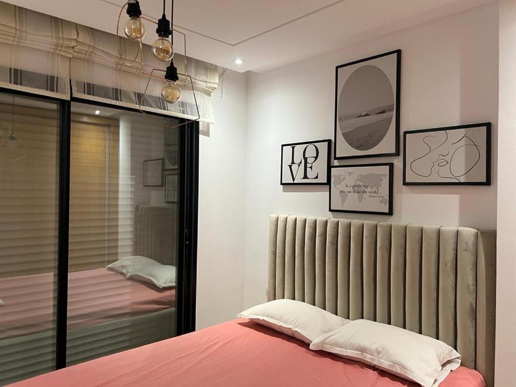苏塞Superbe Appartement kantaoui sousse的一间卧室配有一张带粉色床单和镜子的床