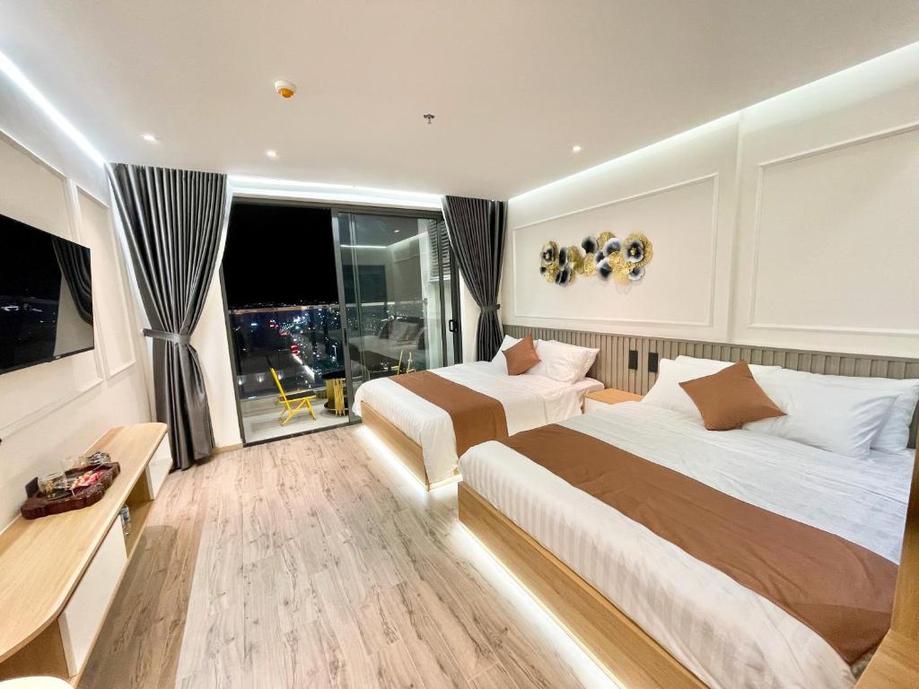 绥和市Kings House Apec Condotel Phú Yên的酒店客房设有两张床和窗户。