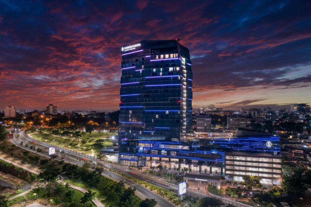 罗安达InterContinental Luanda Miramar, an IHG Hotel的一座高大的建筑,晚上在城市里亮着灯