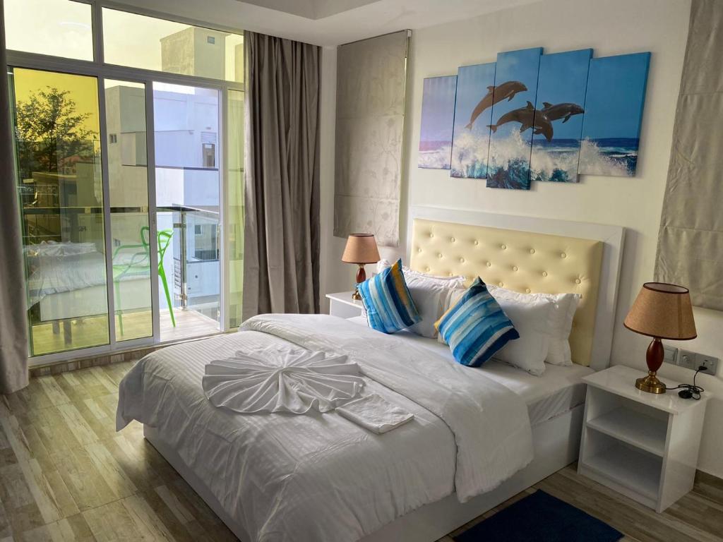 胡鲁马累Marine Holiday的一间卧室配有一张带蓝色和白色枕头的床