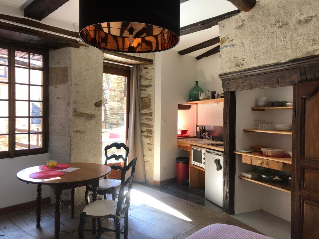 Conques-en-RouergueLA CONQUISE的厨房以及带桌椅的用餐室。