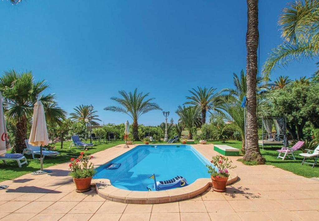 拉马丽娜Villa Teresa的棕榈树度假村内的游泳池