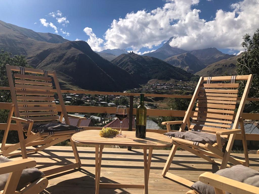 卡兹贝吉Hotel Nestt的山景甲板上配有两把椅子和一张桌子