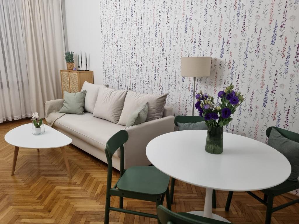 格丁尼亚Apartament na Żeromskiego的客厅配有沙发和2张桌子