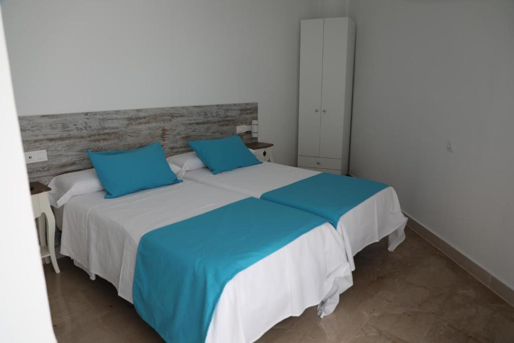 阿利坎特Pension Campello The Blue Med的一间卧室配有一张带蓝色枕头的大床
