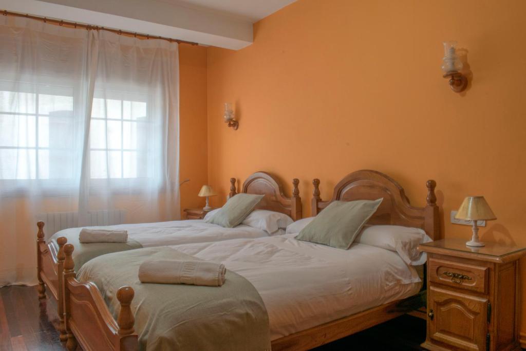 蒙福特·德·莱蒙斯Hostal Galicia的一间卧室设有两张单人床和一个窗户。