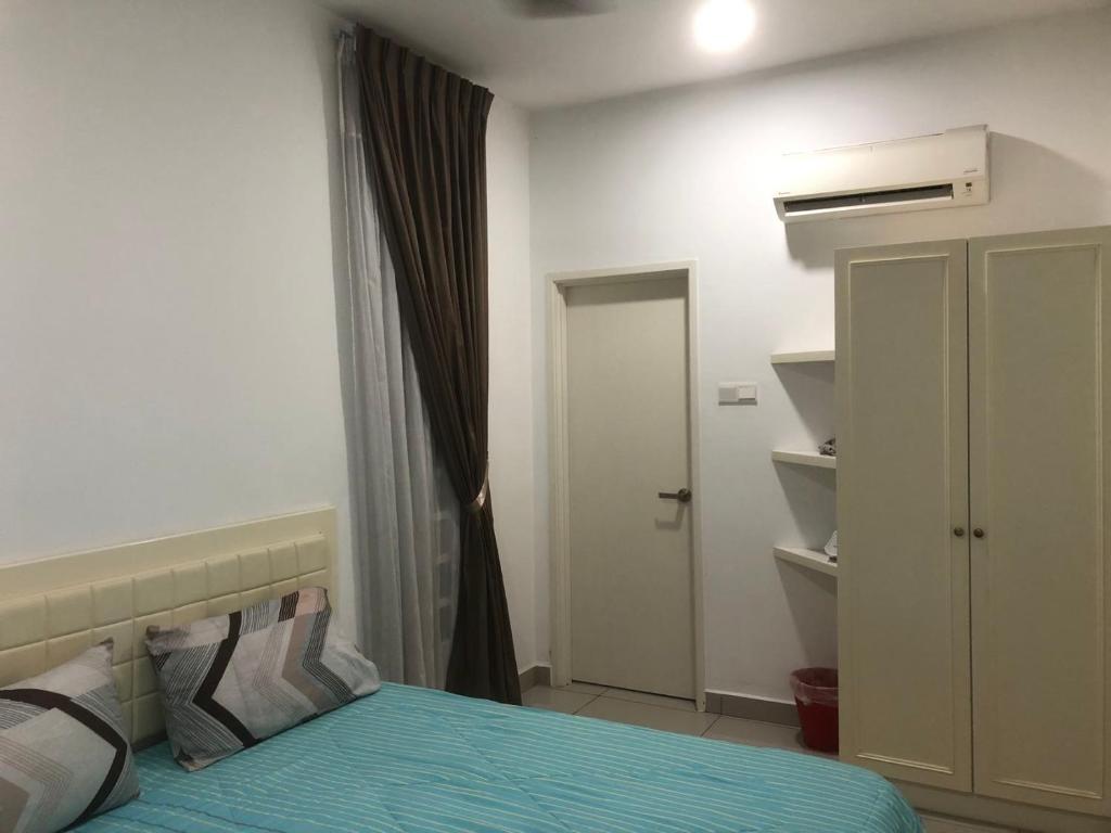 怡保R&C Homestay 5的一间卧室配有一张床和一个衣柜及一扇门