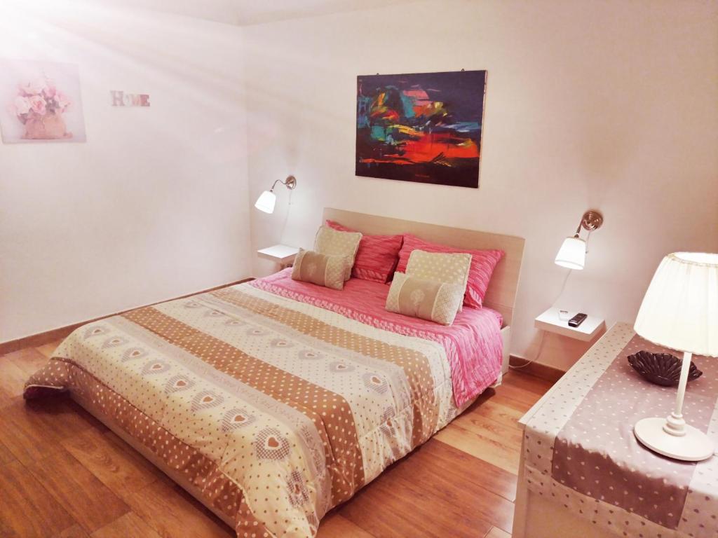 莫尔费塔La Maison apartment的一间卧室配有一张带粉红色棉被的床