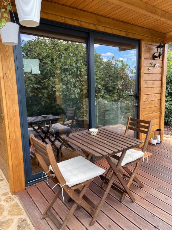 阿尔库什迪瓦尔德维什Lagoon Tiny House的木制甲板配有野餐桌和椅子