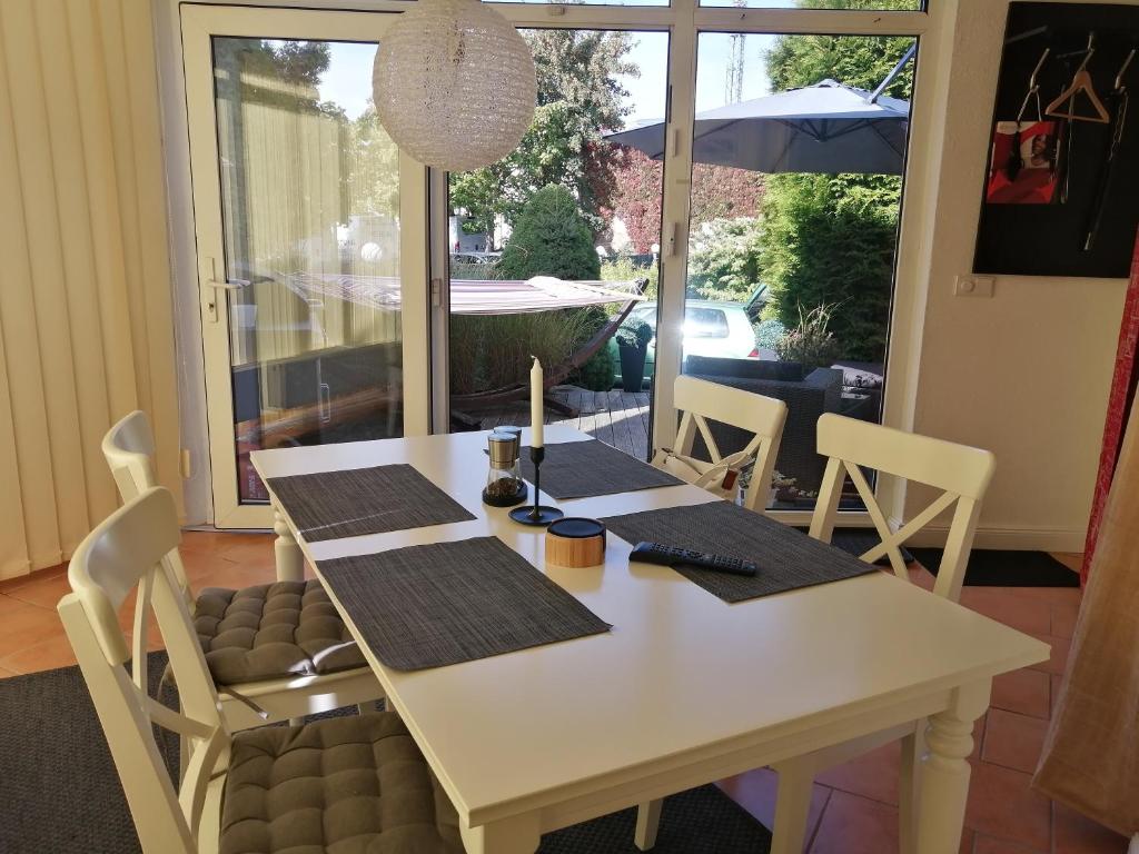 格赖夫斯瓦尔德Schöne Wohnung mit abgeschlossenem Grundstück zentral und ruhig的白色餐桌、椅子和遮阳伞