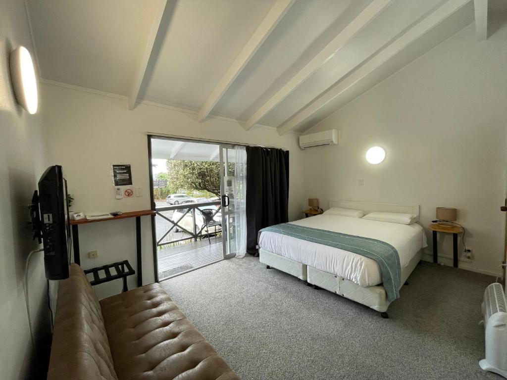 奥克兰午间小憩汽车旅馆的一间卧室配有一张床、一张沙发和一个窗口