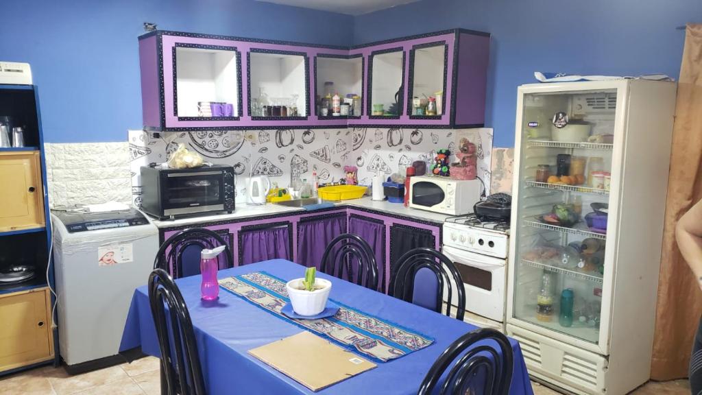 特尔马斯德里奥翁多La casa de valle的厨房配有紫色橱柜、桌子和冰箱。