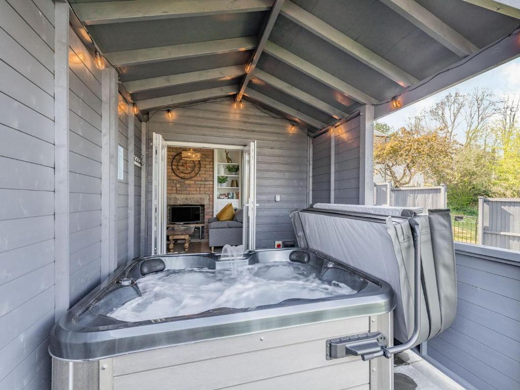 贝克韦尔Spa Cottage的房屋内设有一个按摩浴缸