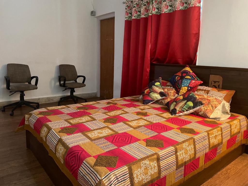 浦那Serene Living的一间卧室配有一张带五颜六色被子的床和两把椅子