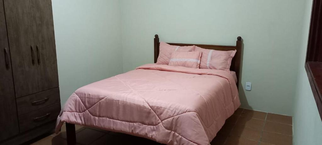 塞拉内格拉Campo dos Sonhos的一张带粉红色棉被和枕头的床