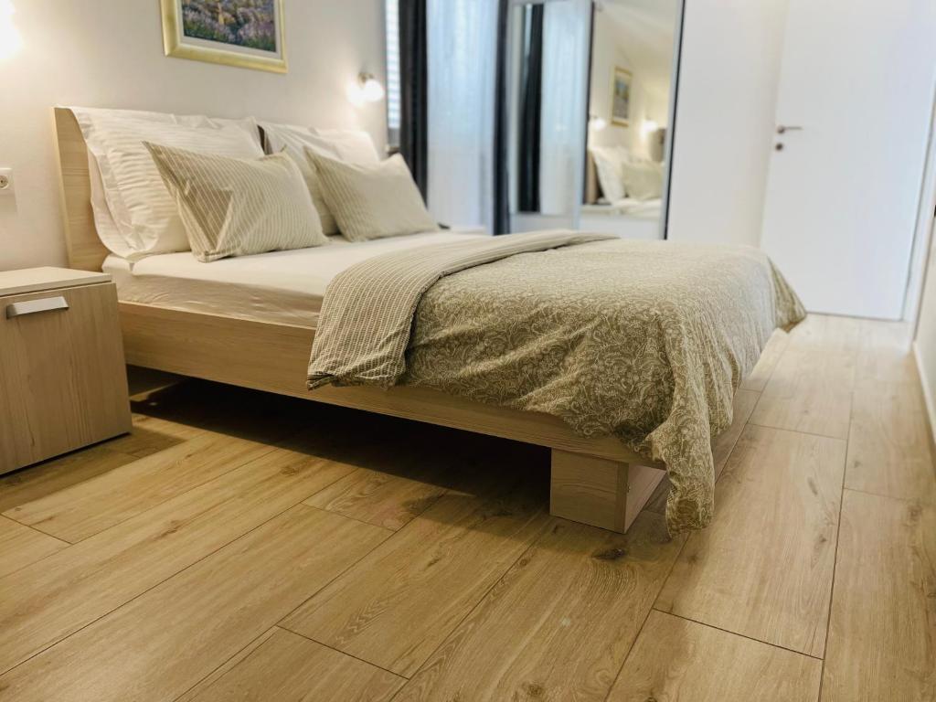 科尔丘拉Apartment Marina的卧室内的一张床位,铺有木地板