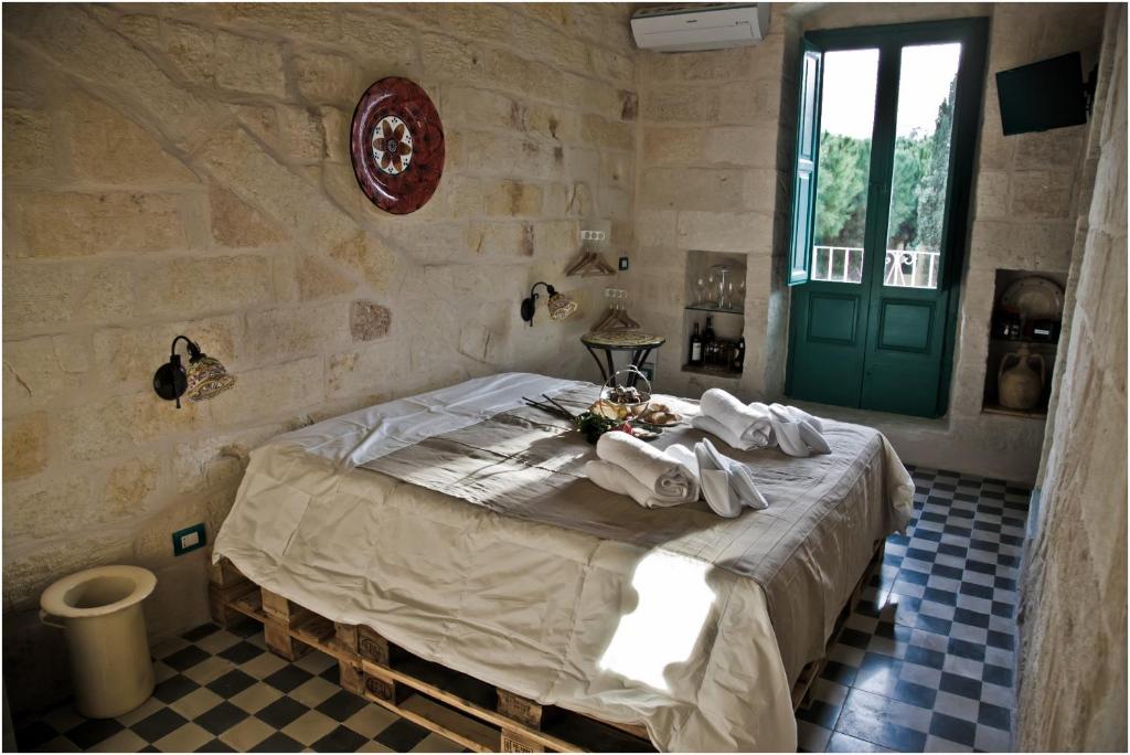 滨海波利尼亚诺拉萨雷拉旅馆的一间卧室配有带毛巾的床