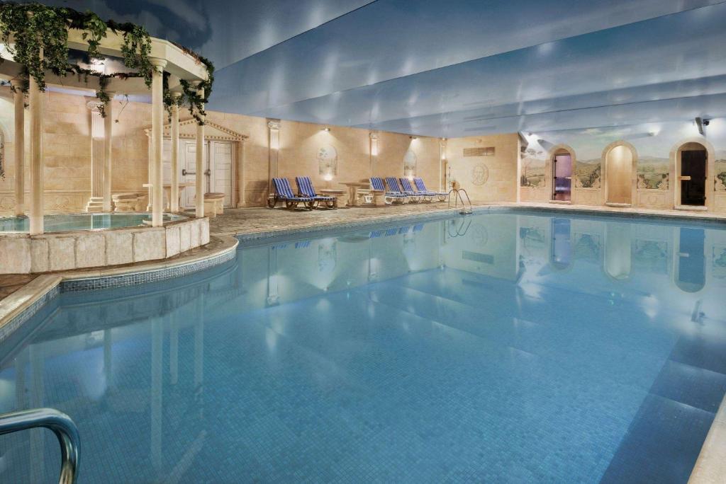 阿斯克Cwrt Bleddyn Hotel & Spa的大楼内一个蓝色的大型游泳池
